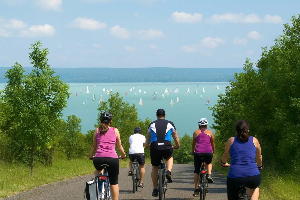 Balatoni Birngakörút-on bicikliző baráti társaság, háttérben a Balatonnal