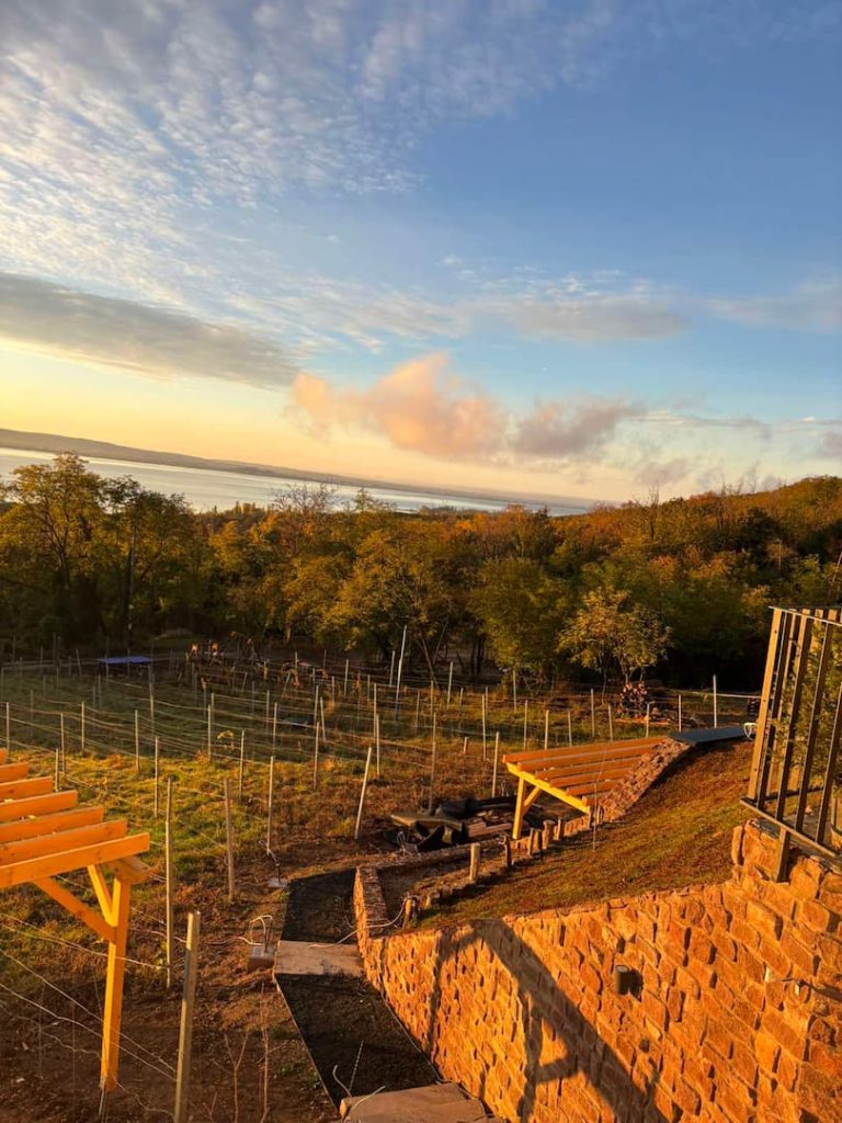 Naplemente fényeiben a Borkúria borospincéhez vezető lejárata háttérben a balatoni panorámával